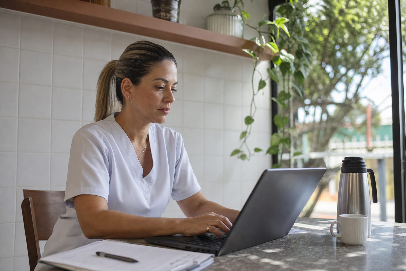 Coordenadora de enfermagem monta a escala do mês no computador de uma sala de empresa de home care