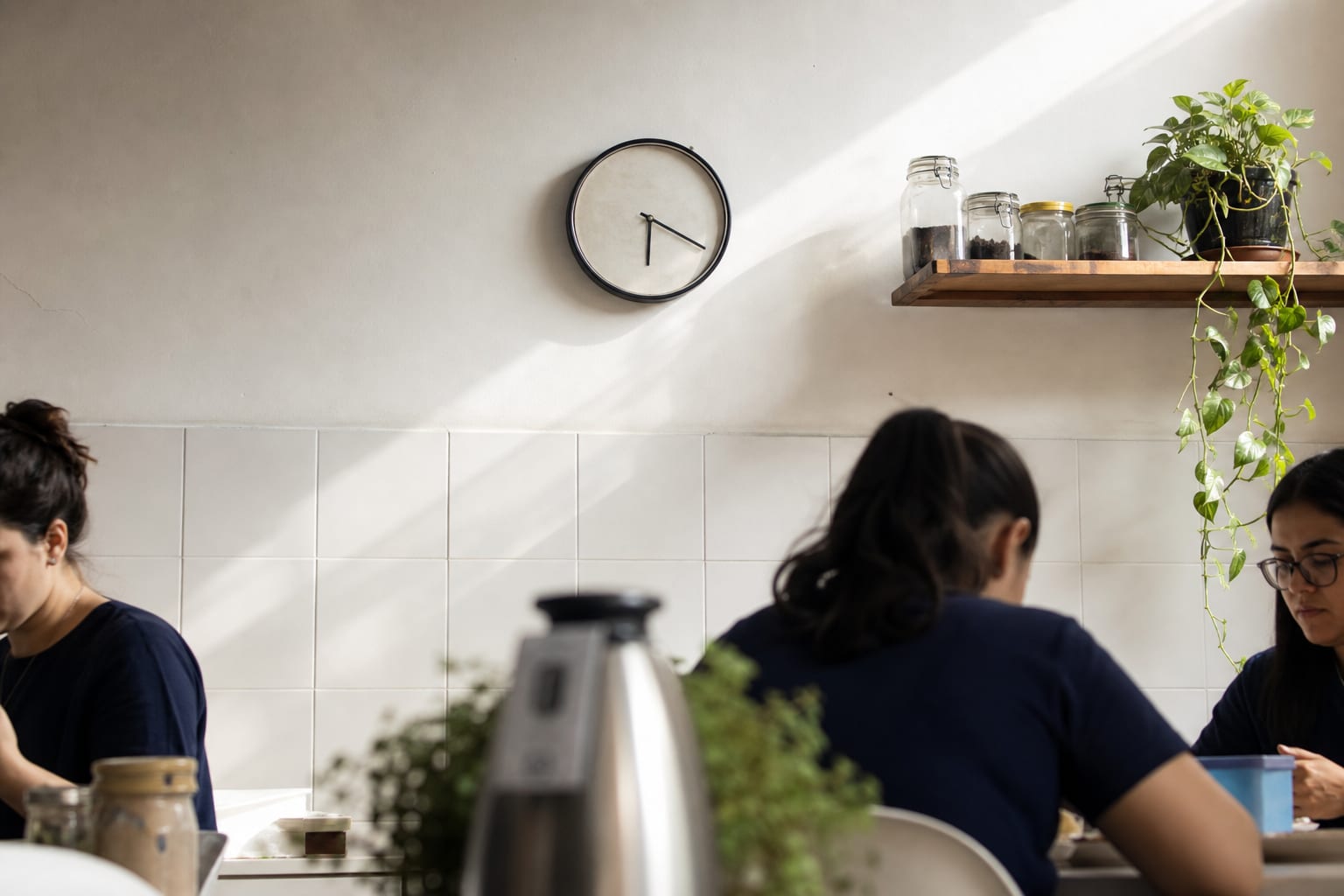 Relógio de parede numa sala administrativa de home care iluminada pela luz azulada do amanhecer